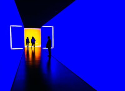 silhouette of 3 distant figures standing in hall