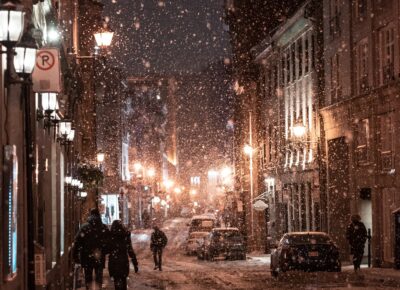 Snow falling under streetlights on city street