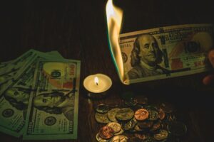 Money and coins on a table with a candle capture unusual moments, hinting at the unexpected in 2025.