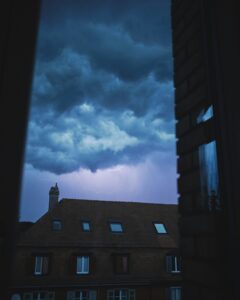 A storm brews over a building, hinting at unusual HVAC moments that might challenge commercial HVAC systems in 2025.