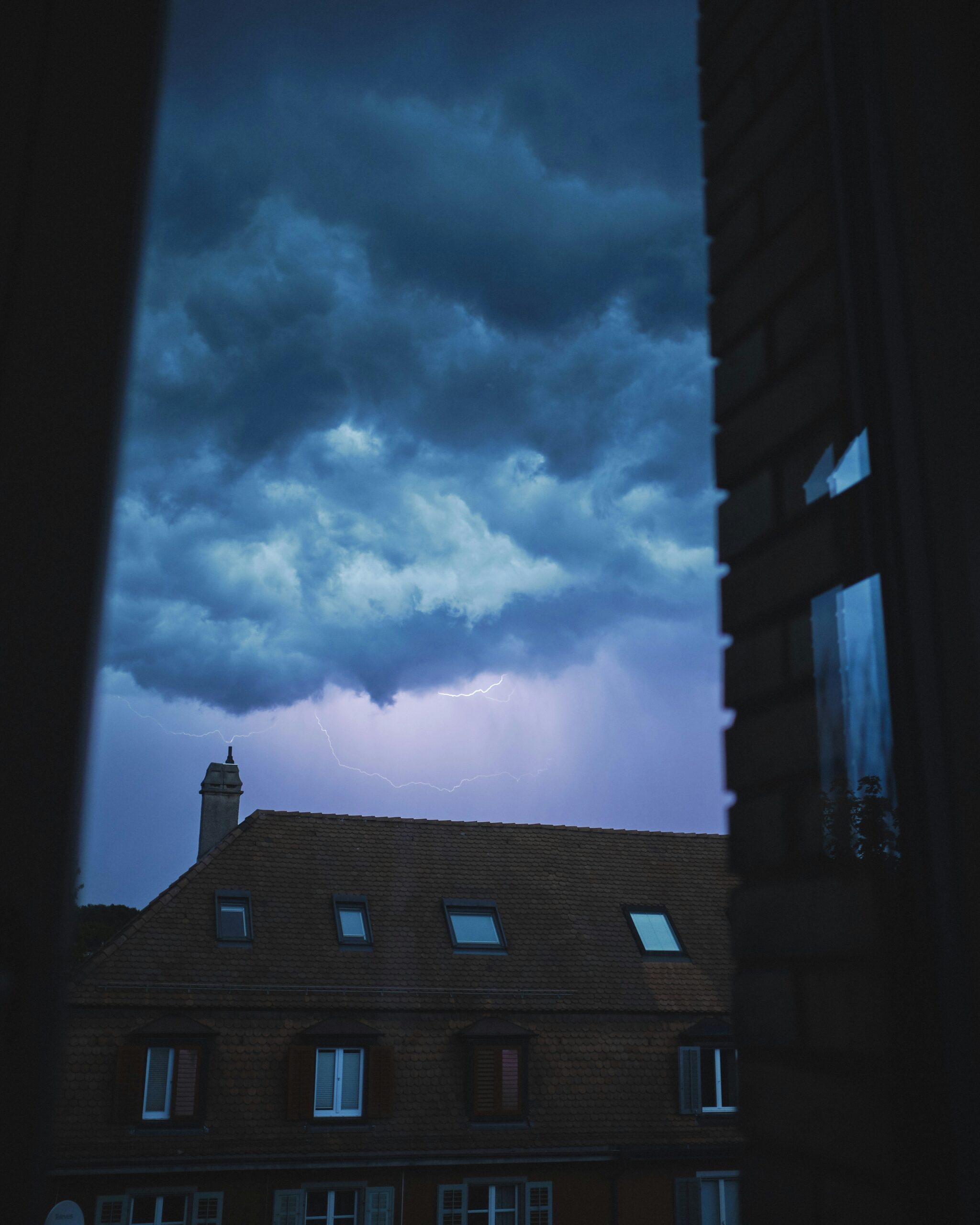 A storm brews over a building, hinting at unusual HVAC moments that might challenge commercial HVAC systems in 2025.