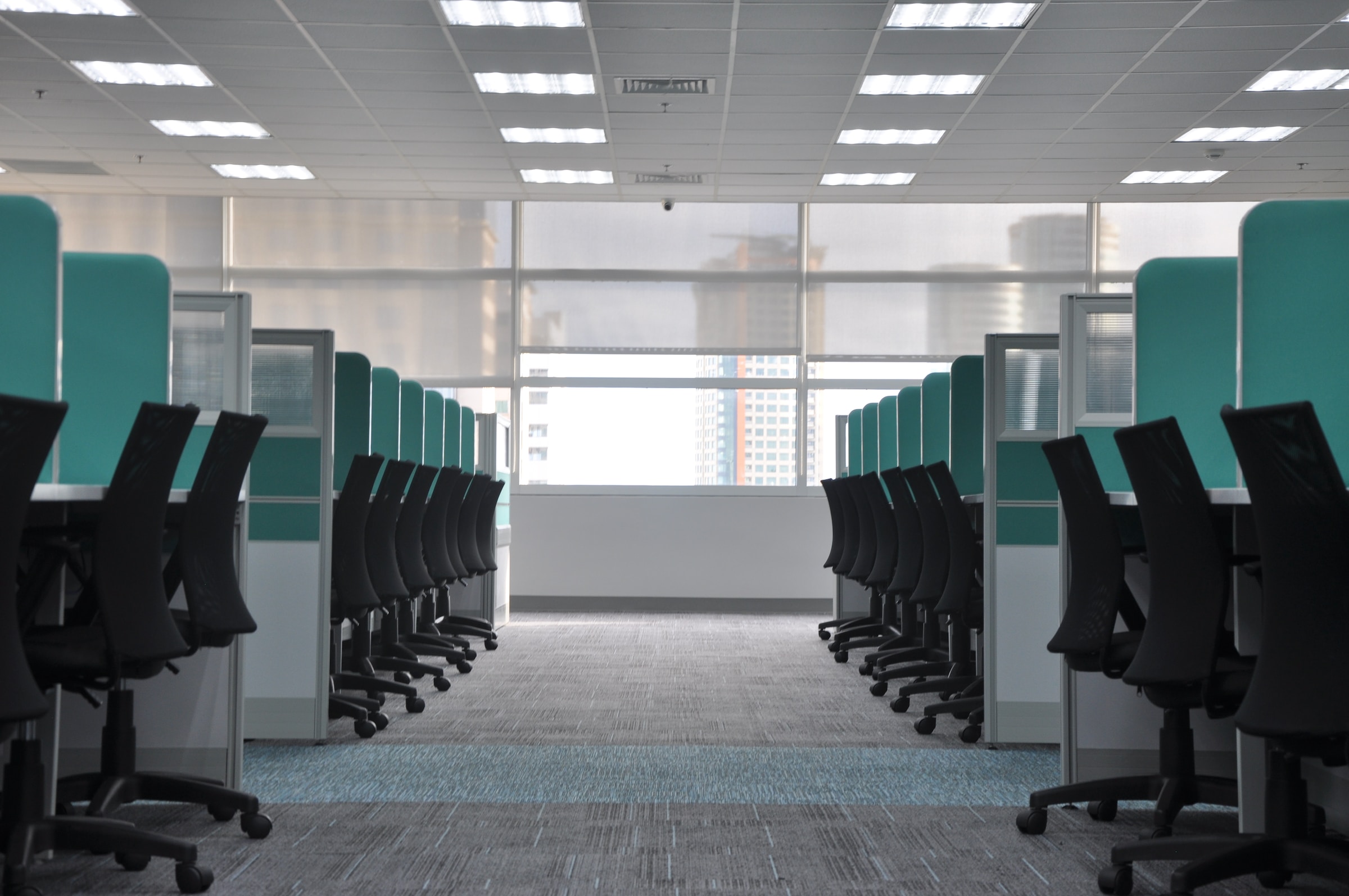 Rows of empty office chairs and desks in a modern office space with large windows and bright overhead lighting—an ideal setting for Commercial HVAC efficiency, ready to handle even the most Unusual HVAC Moments in 2025.