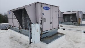 Large commercial HVAC units with Carrier branding sit atop a flat white roof under an overcast sky—capturing one of those unusual moments in 2025 when cutting-edge comfort meets industrial design.