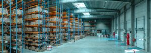 Large warehouse interior with high shelves filled with boxes and pallets, concrete floors, loading docks, and commercial HVAC for optimal climate control—ready to handle any unusual moments that 2025 may bring.