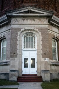 The entrance of a brick building labeled Water Works with double doors and a Closed sign in the window.
