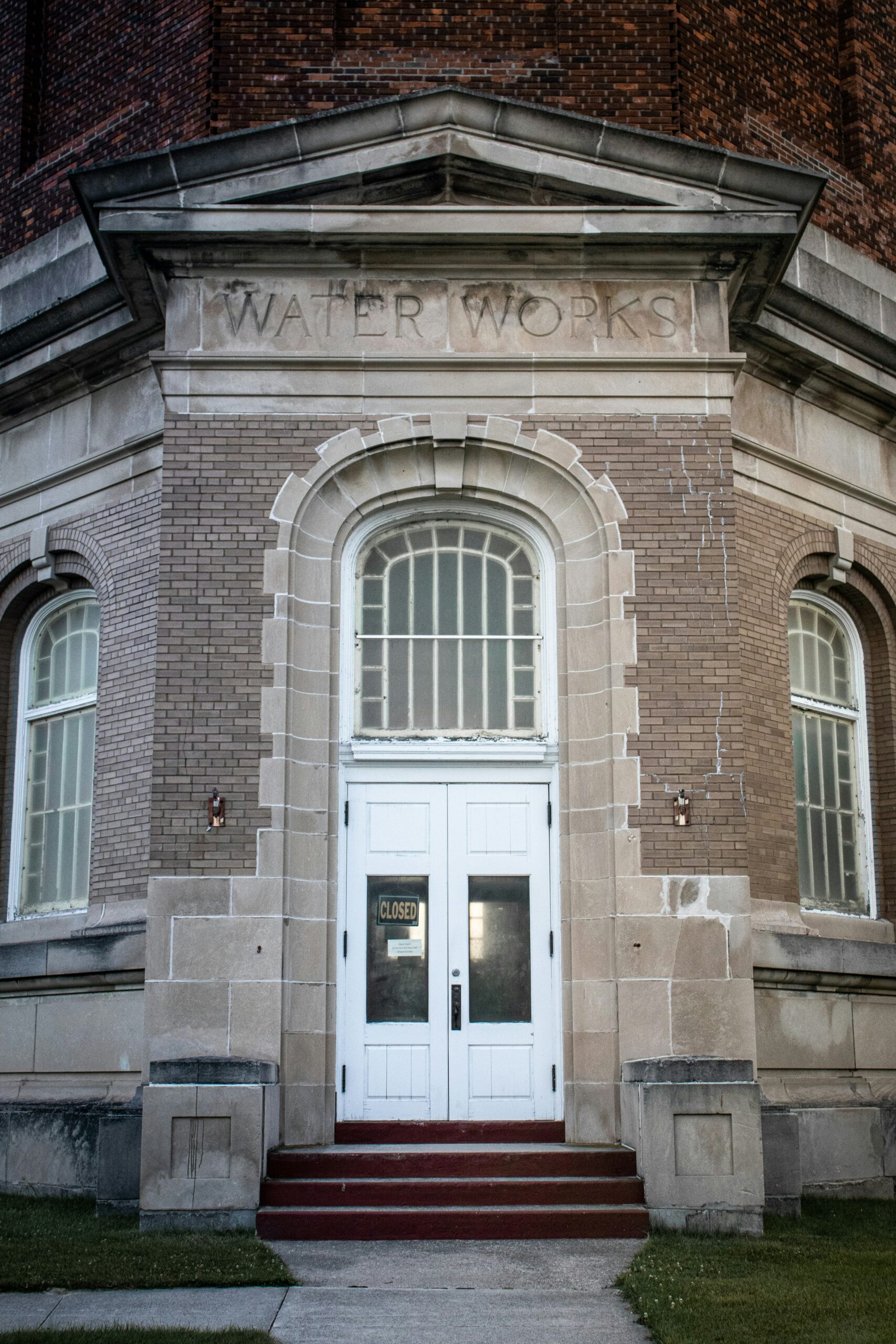 The entrance of a brick building labeled Water Works with double doors and a Closed sign in the window.